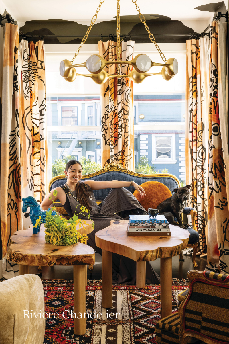 woman sitting on a sofa with décor and a chandelier hanging above